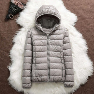 Veste matelassée à capuche, fermeture zippée, couleur gris clair.