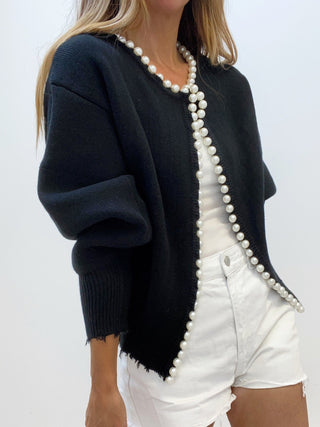 Cardigan en tricot noir ouvert, bordure perlée blanche, ourlet et poignets frangés