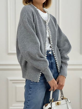 Cardigan en tricot gris ouvert, bordure de perles blanches le long du devant