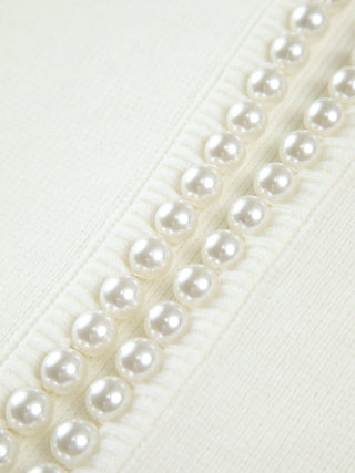 Bordure en perles blanches sur cardigan en tricot crème, détail de couture