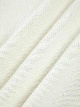 Cardigan en tricot crème, maille texturée visible, gros plan sur la manche