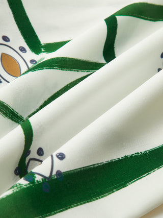 Tissu d’ensemble court imprimé : fond blanc, motifs verts et bleus, bord liseré vert