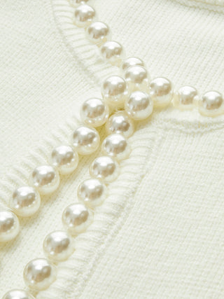 Empiècement de perles sur cardigan en tricot crème, gros plan des perles