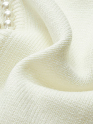 Cardigan en tricot crème, gros plan sur la maille et la finition du bord