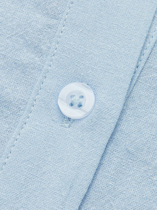 Bouton rond sur chemise en lin bleu clair