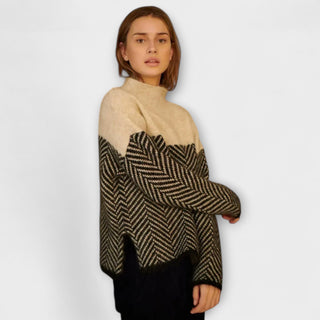 Pull à col montant beige, motif chevrons noir et gris, porté croisé, manches longues