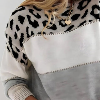 Pull en tricot blanc avec grand motif léopard noir et empiècement gris en bas.