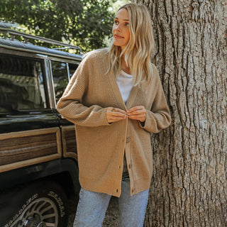 Cardigan en cachemire beige, boutonné devant, encolure en V et manches longues.