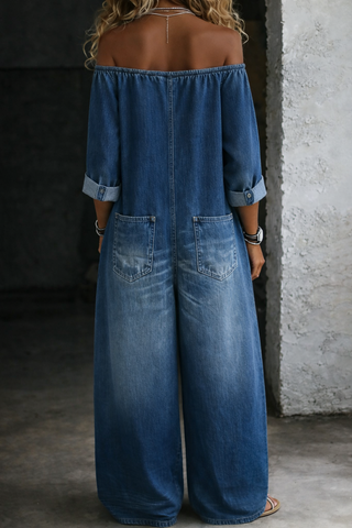 Combinaison longue en jean bleu, encolure épaules dénudées, patte de boutons, poches.