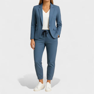 Ensemble veste et pantalon bleu, veste à revers, pantalon à cordon noir.