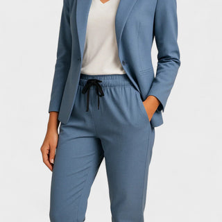 Ensemble veste et pantalon bleu, détail pantalon à cordon noir et poches.