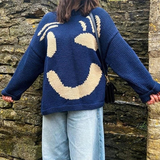 Pull en tricot épais bleu oversize à motif sourire beige, manches longues.
