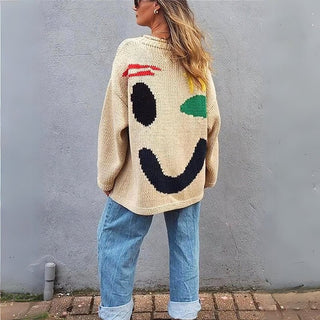 Pull en tricot épais crème oversize, motif sourire visible au dos et manches longues.