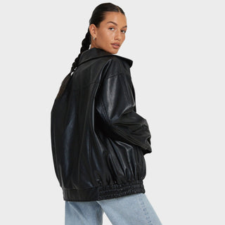 Veste en cuir noire à col montant, zippée, manches bouffantes et taille élastique