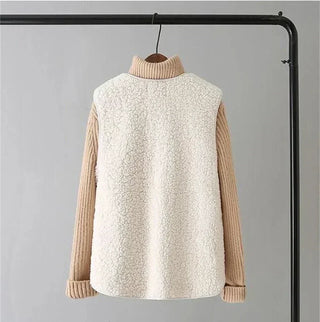 Top manches longues beige sous gilet sans manches blanc cassé à col montant, fermeture par boutons.