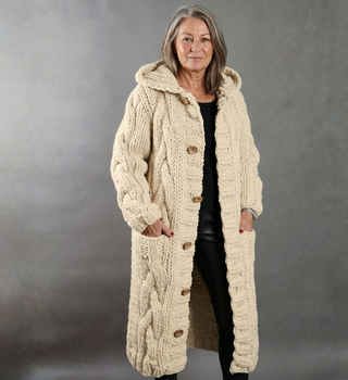 Manteau en tricot beige à motif câble, boutonné, poches et col châle.