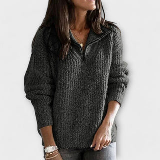 Pull en maille gris foncé à demi-zip, manches longues, texture tricotée.