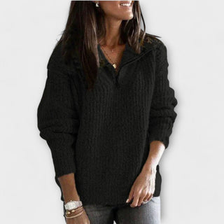 Pull en maille noir à demi-zip, manches longues, texture tricotée.