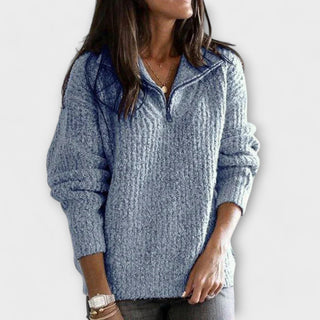 Pull en maille bleu à demi-zip, manches longues, texture tricotée.