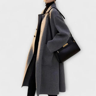 Manteau long thermique foncé, col droit, patte boutonnée, poches plaquées