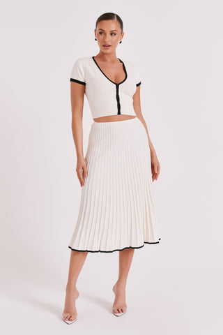 Ensemble blanc : top court col V à boutons noirs et jupe midi plissée, coupe droite