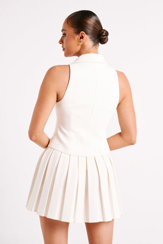 Robe blanche courte vue de dos, dos en V, sans manches et jupe plissée