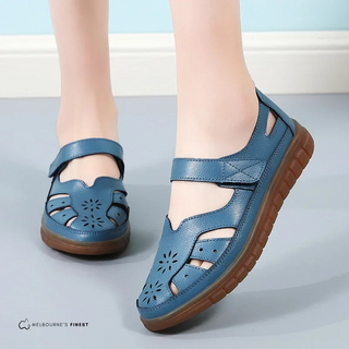 Chaussures orthopédiques réglables bleu clair à velcro, semelle marron, ajourées.