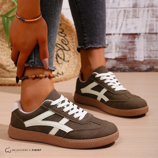Chaussures orthopédiques foncées avec empiècements blancs, lacets et semelle gomme