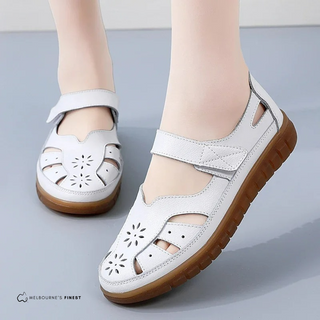 Chaussures orthopédiques réglables blanches à velcro, semelle marron, ouvertures.