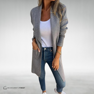 Cardigan long Gris à col châle, porté ouvert, poches plaquées, manches longues.
