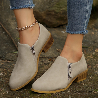 Bottines orthopédiques gris clair à fermeture éclair, talon bloc et semelle épaisse.
