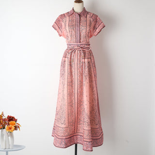 Ensemble blouse et jupe imprimées rose, col boutonné, ceinture à la taille.