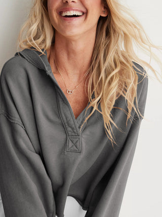 Hoodie gris foncé pour femme, capuche et zip devant, tissu molletonné visible.