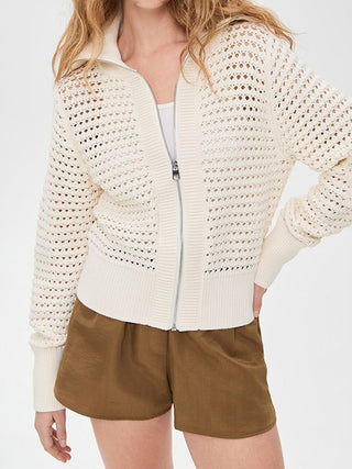 Cardigan zippé en tricot ajouré blanc cassé, col montant, poches passepoilées.