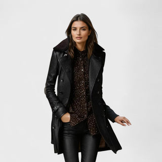 Manteau en cuir noir, fermeture boutonnée, poches, coupe mi-longue avec fente.