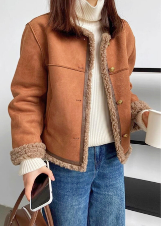 Veste camel à doublure moutonneuse, poches poitrine, poignets en fourrure et boutons dorés.