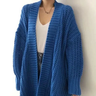 Manteau long bleu en maille côtelée, col châle, manches larges, devant ouvert.