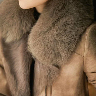 Col en fourrure épaisse brun-gris sur manteau en suède taupe.