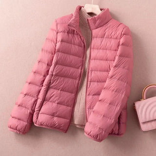 Doudoune matelassée rose à fermeture zippée et col montant, manches longues.