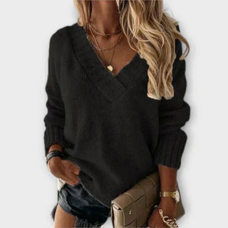 Pull en maille noire, col V, manches longues, coupe ample.