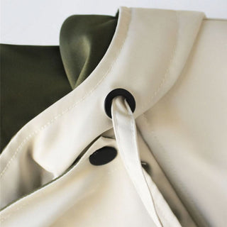 Détail col et patte de boutonnage de veste bicolore vert olive et crème.
