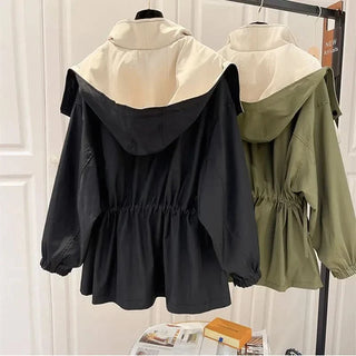 Parka à capuche noire et verte, taille froncée, manches bouffantes.