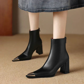 Bottes femme noires à talon bloc, bout pointu, tige mi-mollet, look cuir lisse.