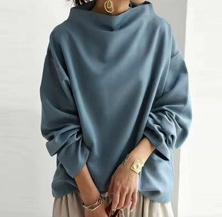Pull femme bleu à col montant, silhouette droite, manches longues amples.