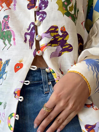 Détail blouse blanche imprimée : rangée de boutons et col, manches à poignets élastiques