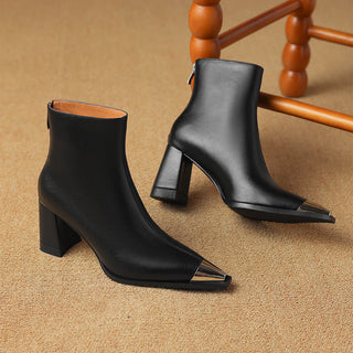 Paire de bottes noires pour femme à talon bloc, bout pointu, tige mi-haute.