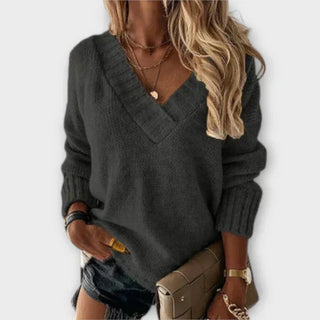 Pull en maille gris foncé, col V, manches longues, coupe ample.
