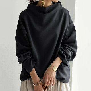 Pull femme noir à col montant, coupe droite, manches longues bouffantes.