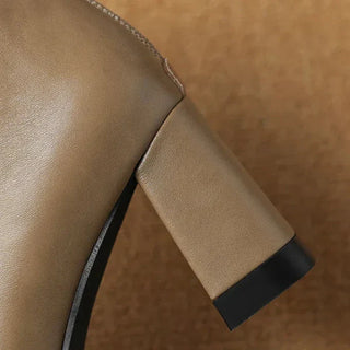Détail du talon bloc noir et de la tige beige clair sur botte à bout pointu.
