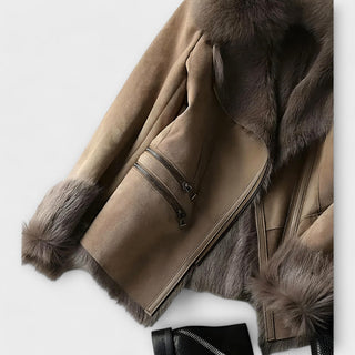 Manteau suédé taupe : manches fourrées, ourlet, fermeture zippée noire.